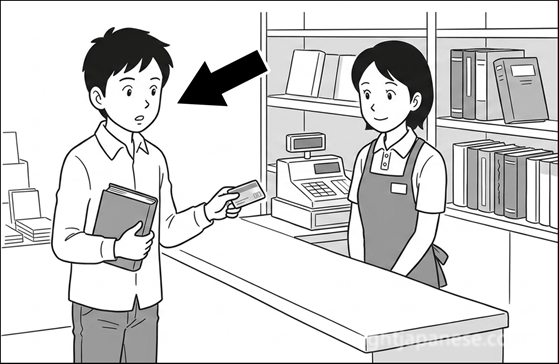 A man holding a book and a credit card at a bookstore counter, about to ask the clerk a question